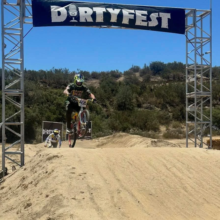 A mountain biker riding beneath a Dirtyfest event arch